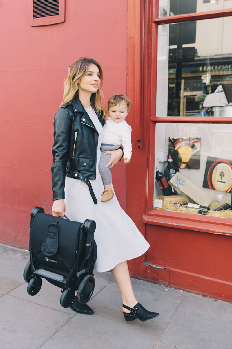 Woman holding baby and stroller