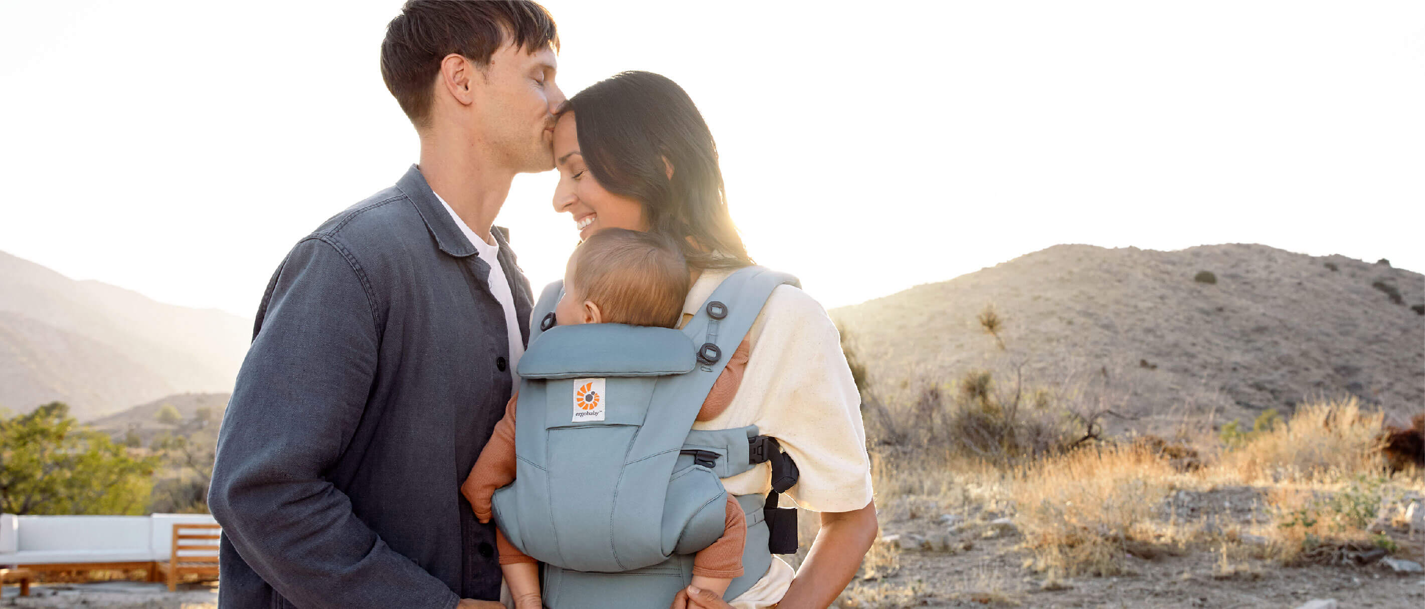 Photo parent carrying child in Omni Dream carrier outward facing