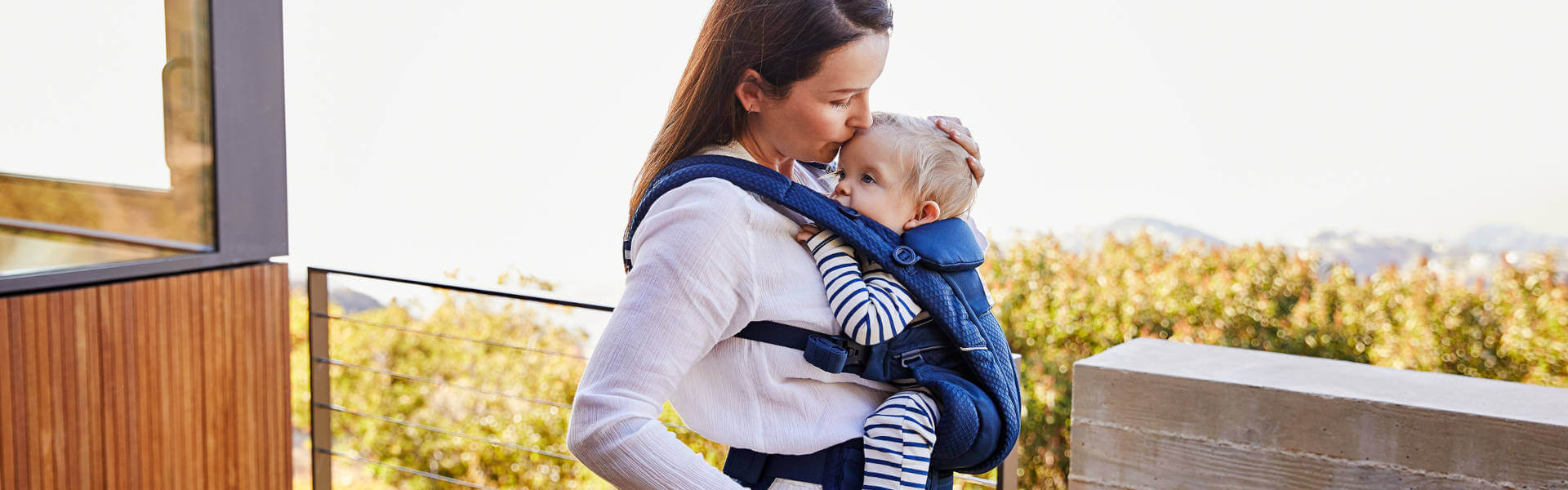 Mom carrying baby in an Ergobaby Omni Breeze Baby Carrier